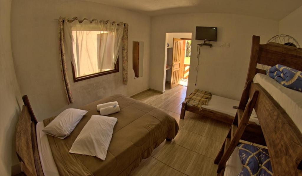 a small bedroom with a bed and a window at Pousada Natalino Broleze in Águas de Lindoia
