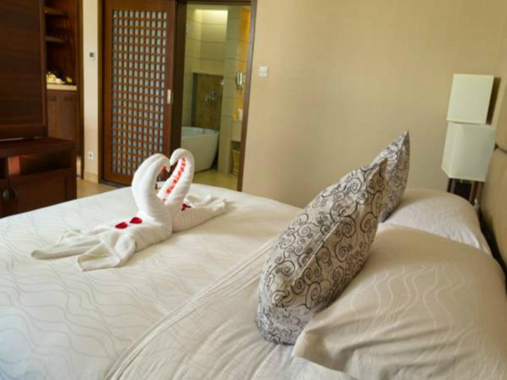 a bedroom with a bed with towels on it at Kangte Wangfu Hotel of Resort And Conference in Sanya