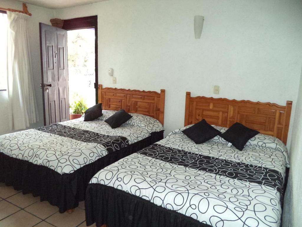 dos camas sentadas una al lado de la otra en un dormitorio en Hotel Ocampo, en Oaxtepec