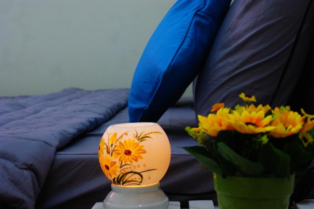 a vase with flowers on a table next to a couch at Hotel An Nhien in Buon Ma Thuot