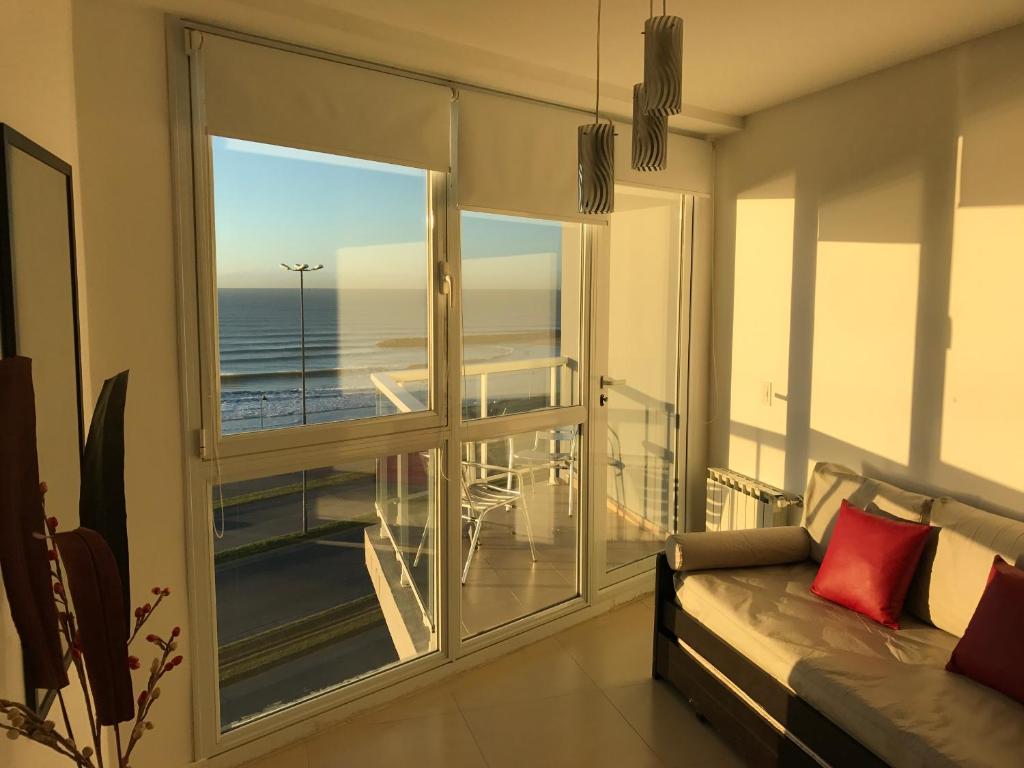a living room with a couch and a view of the ocean at Marco Polo Platinum Apartamento in Mar del Plata