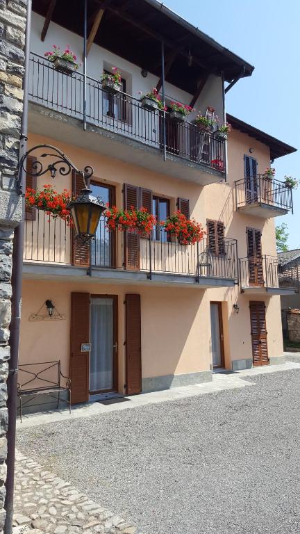 ein Gebäude mit Blumenkästen auf den Balkonen in der Unterkunft B&B CA'SUANA in Lanzo dʼIntelvi