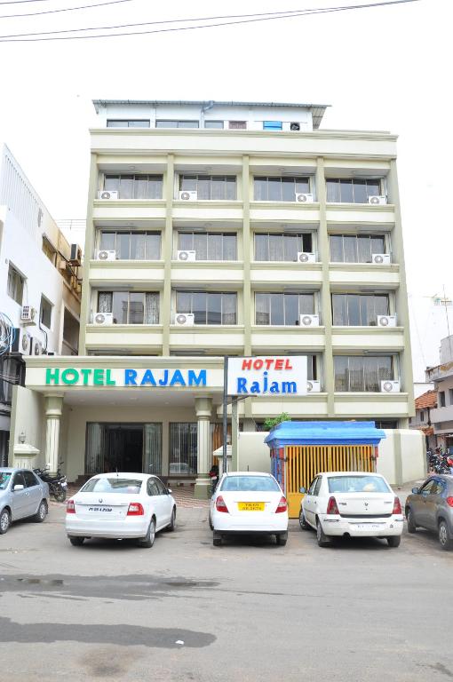 a hotel building with cars parked in front of it at Hotel Rajam in Kanyakumari