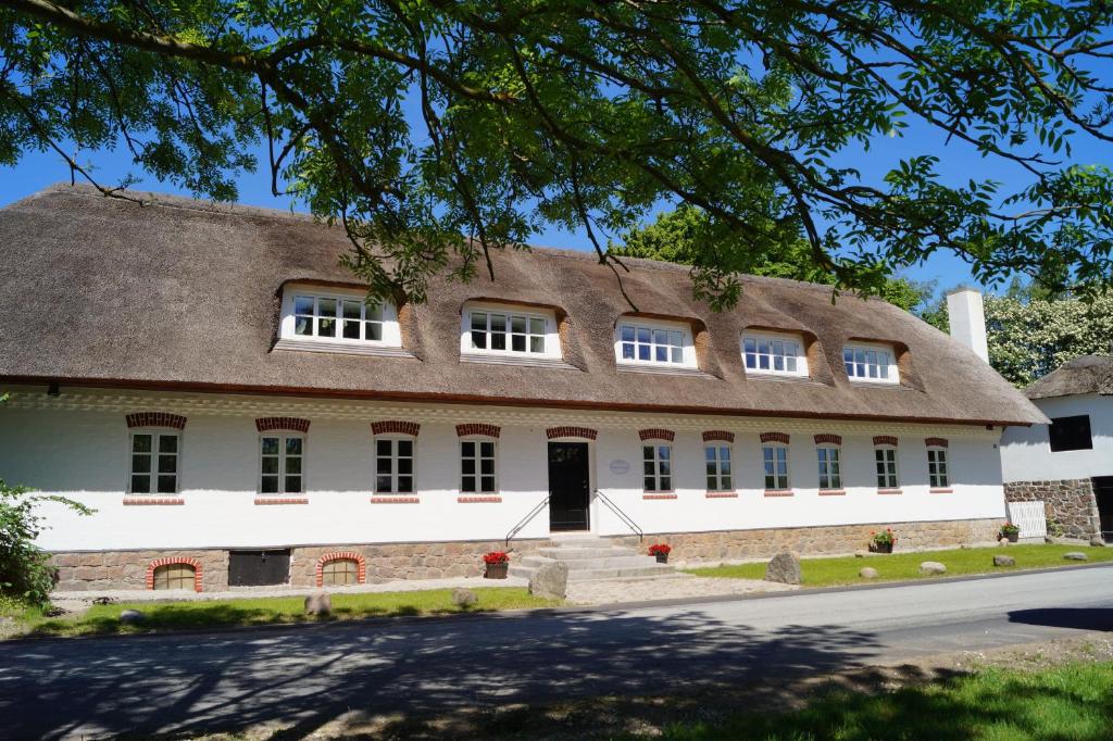 un grand bâtiment avec un toit de chaume dans l'établissement Fuglsø Kro Bed & Breakfast, à Knebel