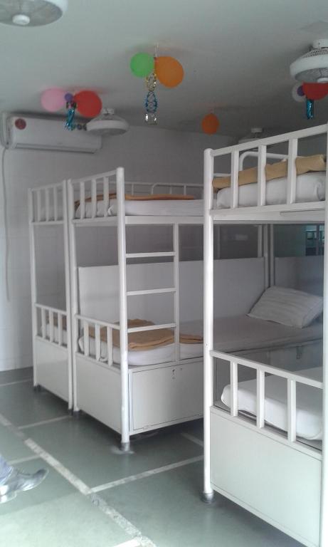Star Dormitory في مومباي: سريرين بيض بطابقين في غرفة