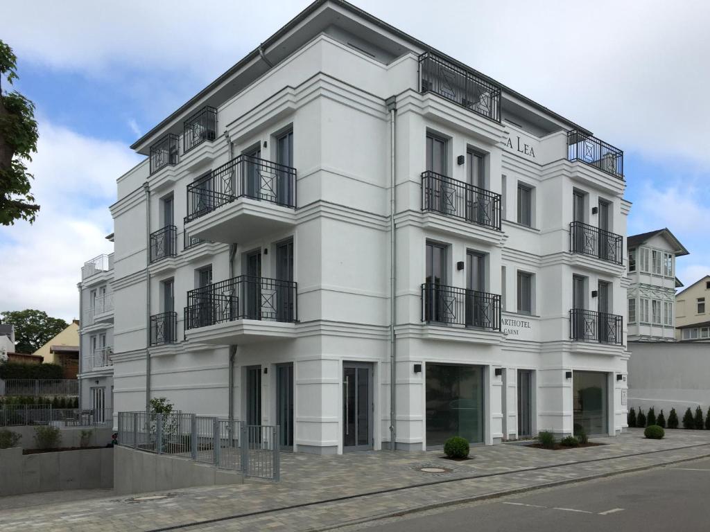 a white building with balconies on a street at Aparthotel Villa Lea in Ahlbeck