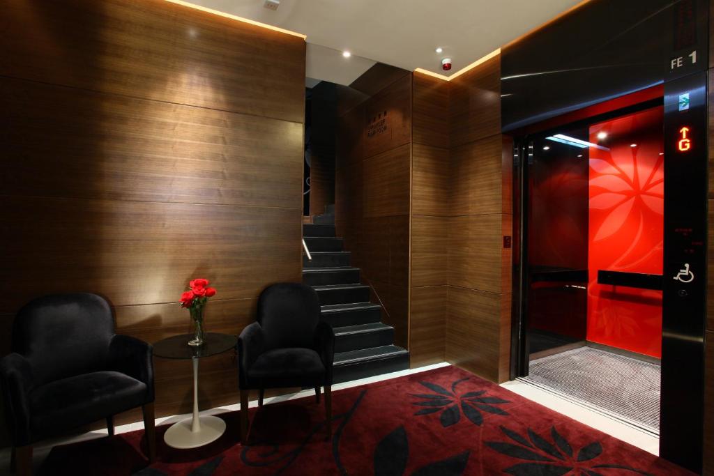 una hall con due sedie e una scala con tappeto rosso di Sohotel a Hong Kong
