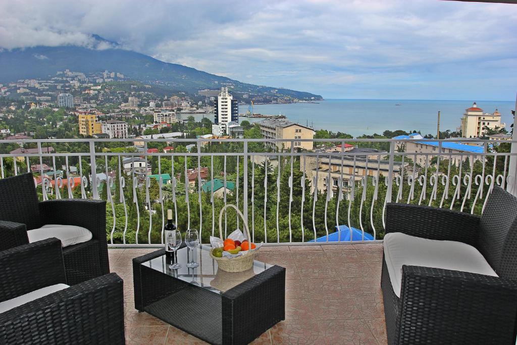 Un balcón con sillas y una mesa con vistas al océano. en Hotel Imperial 2011, en Yalta