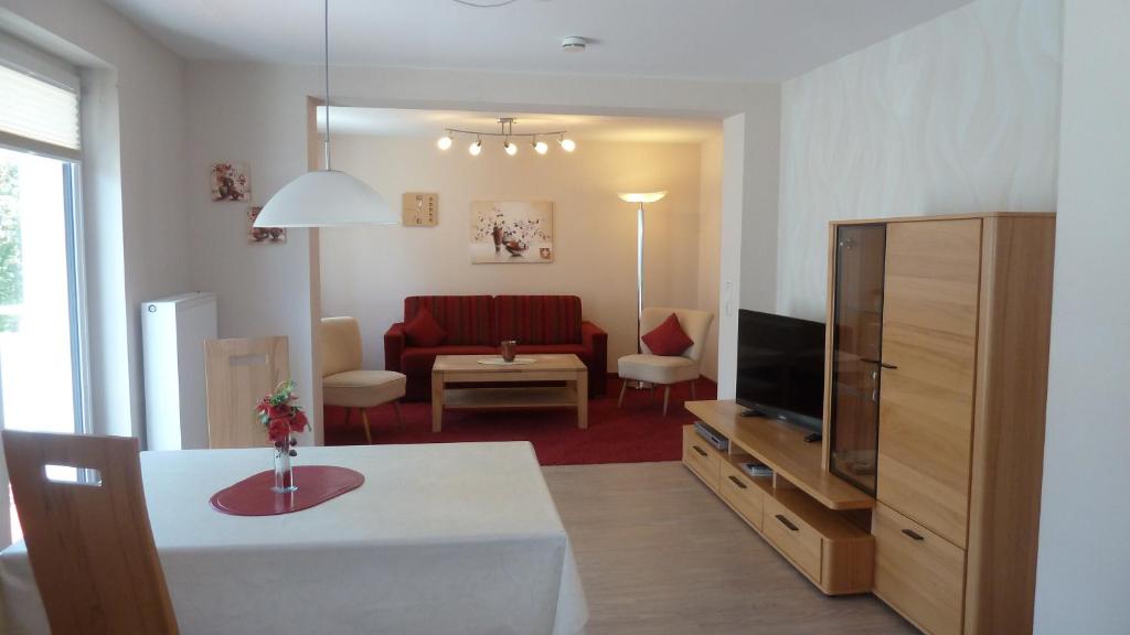 - un salon avec un canapé et une télévision dans l'établissement Ferienwohnungen Mittendrin, à Willingen