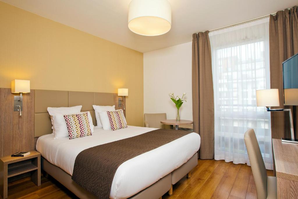 a hotel room with a large bed and a window at Residhome Bois Colombes Monceau in Bois-Colombes