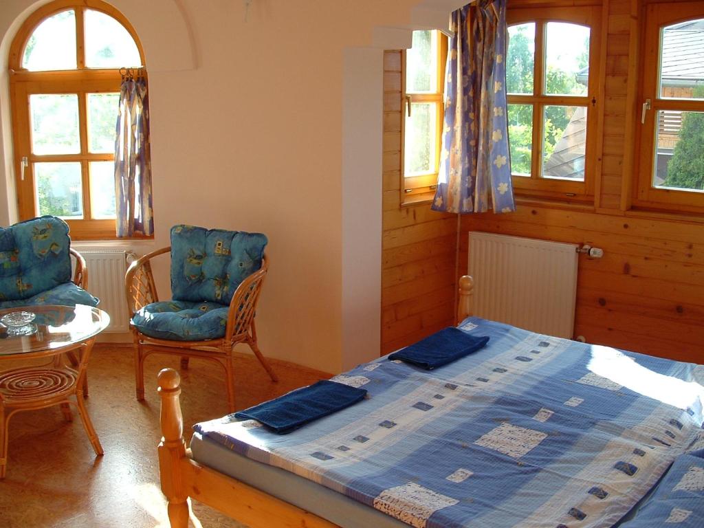 a bedroom with a bed and two chairs and a table at Castle house in Balatonfüred