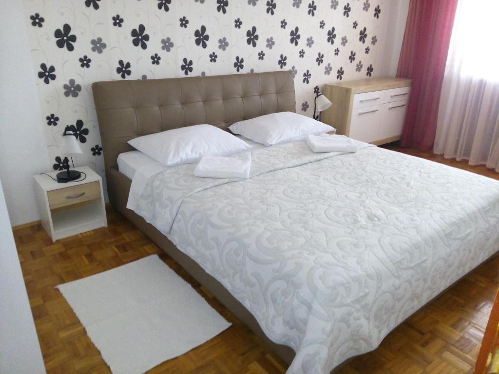 a bedroom with a large bed with white sheets and white pillows at Apartmani Frkic in Tisno