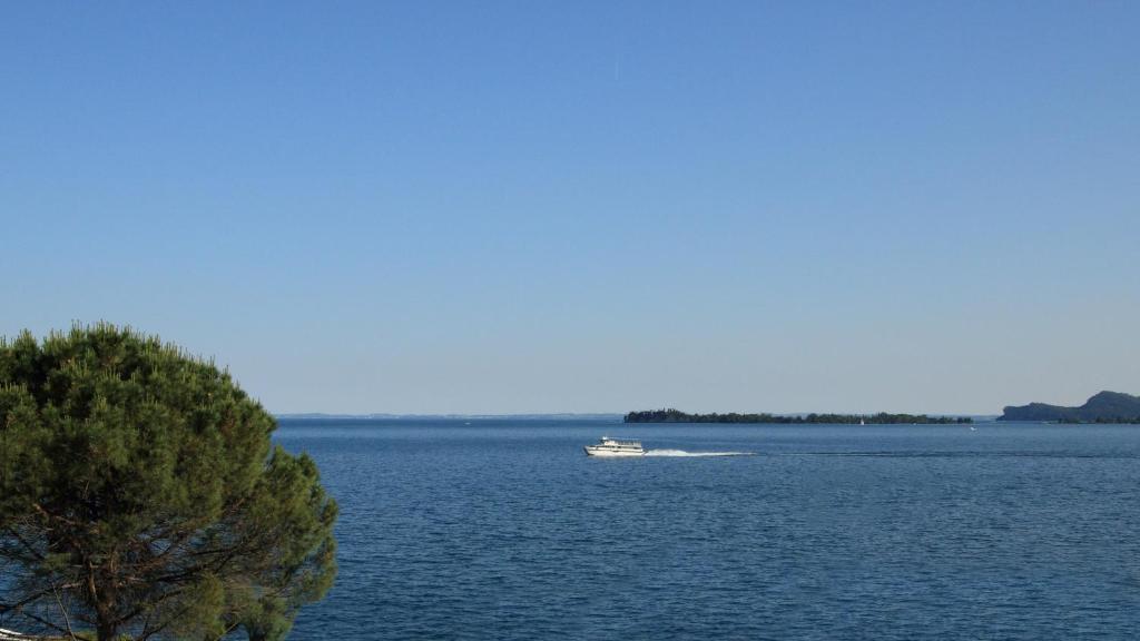 un barco en medio de un gran cuerpo de agua en Hotel Aquavite, en Gardone Riviera