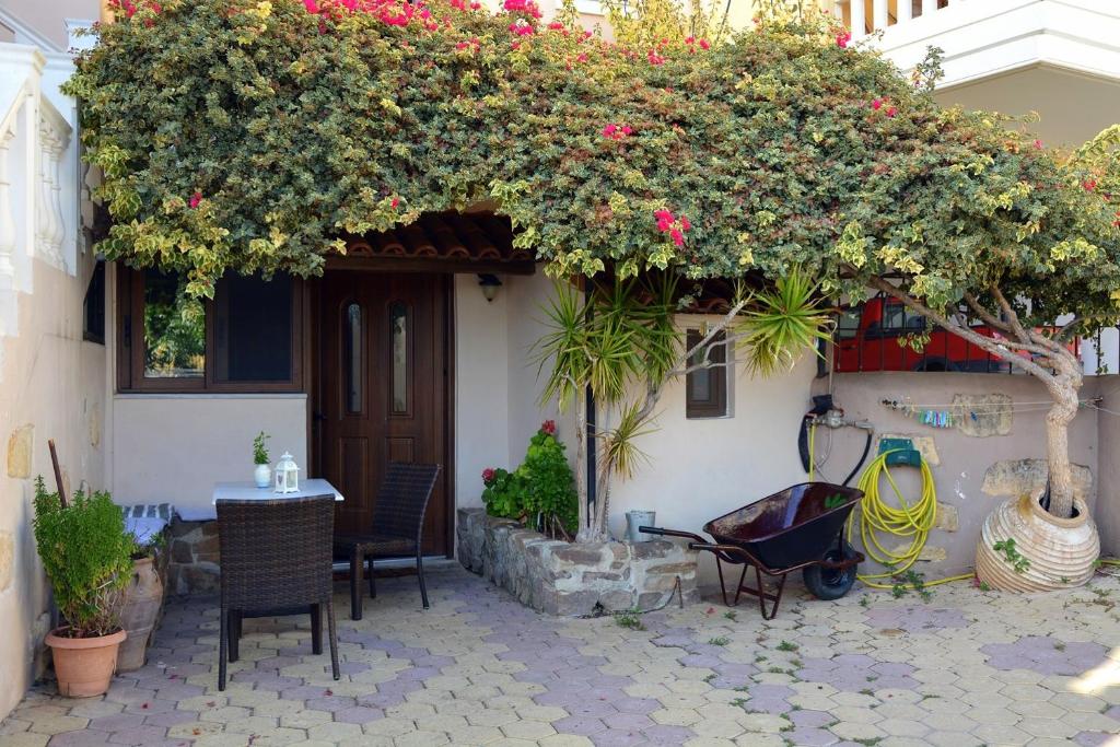 un patio con una mesa y flores en un edificio en Estrella Studios en La Canea