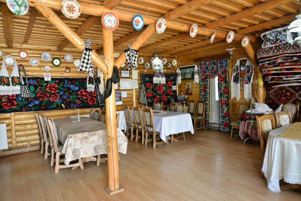 a dining room with tables and chairs and plates on the wall at Pension Ioana Lavita in Vadu Izei