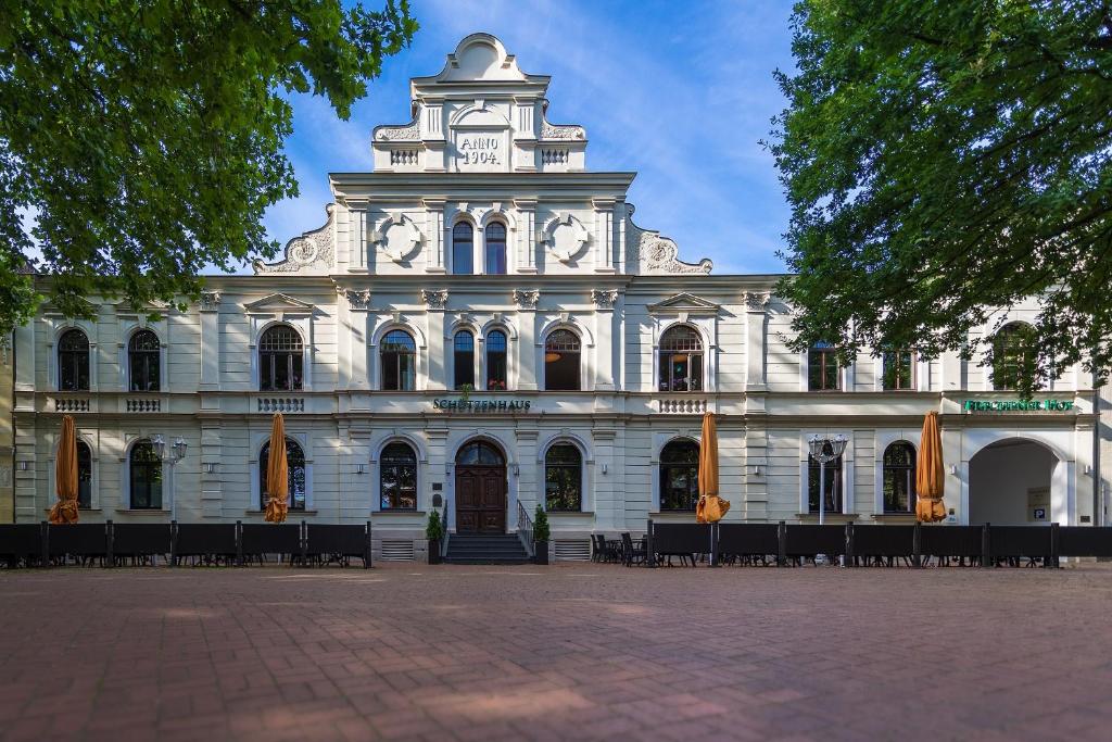 ein großes weißes Gebäude mit einem Turm oben in der Unterkunft Hotel Frechener Hof in Frechen