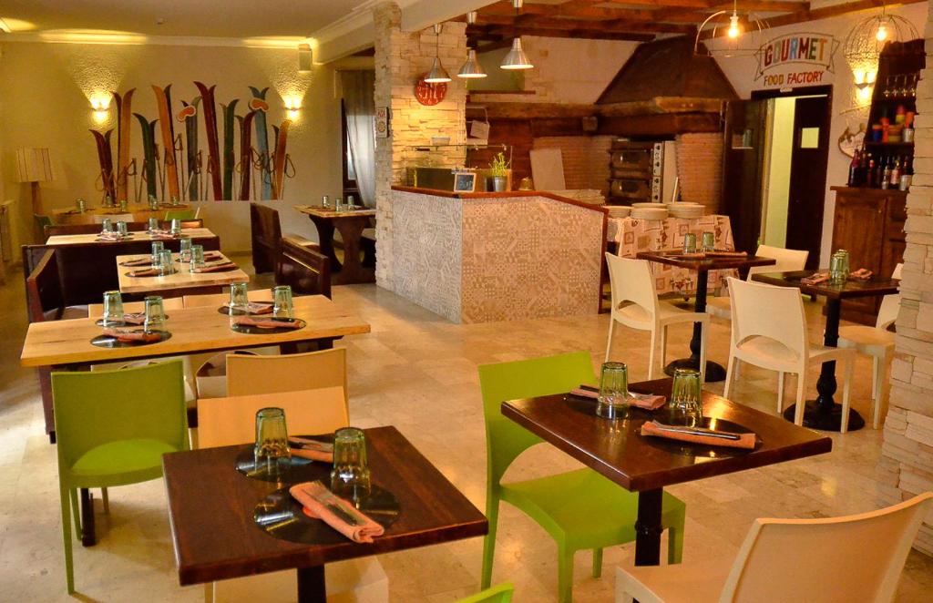 a restaurant with tables and chairs in a room at Hotel San Giorgio in Sauze dʼOulx