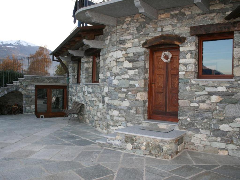 una casa in pietra con una porta in legno e un portico di A due passi da... ad Aosta