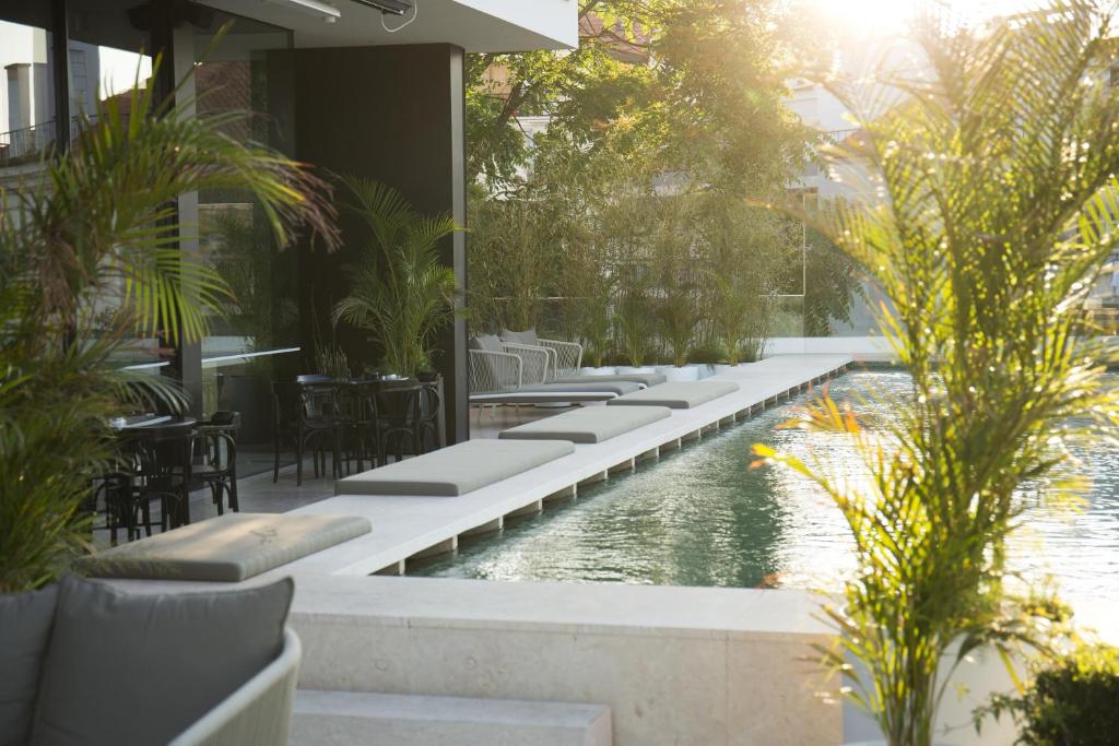 - une piscine dans un complexe avec des chaises et des tables dans l'établissement Memmo Príncipe Real - Design Hotels, à Lisbonne