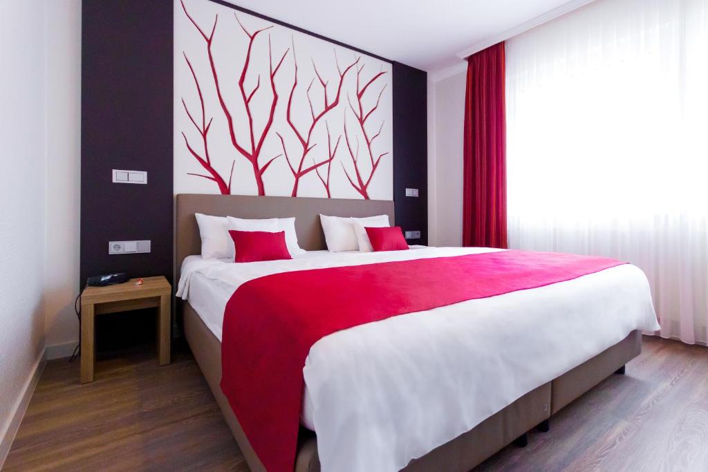 1 dormitorio con 1 cama grande con manta roja en Ferienwohnung Burgblick en Bullay