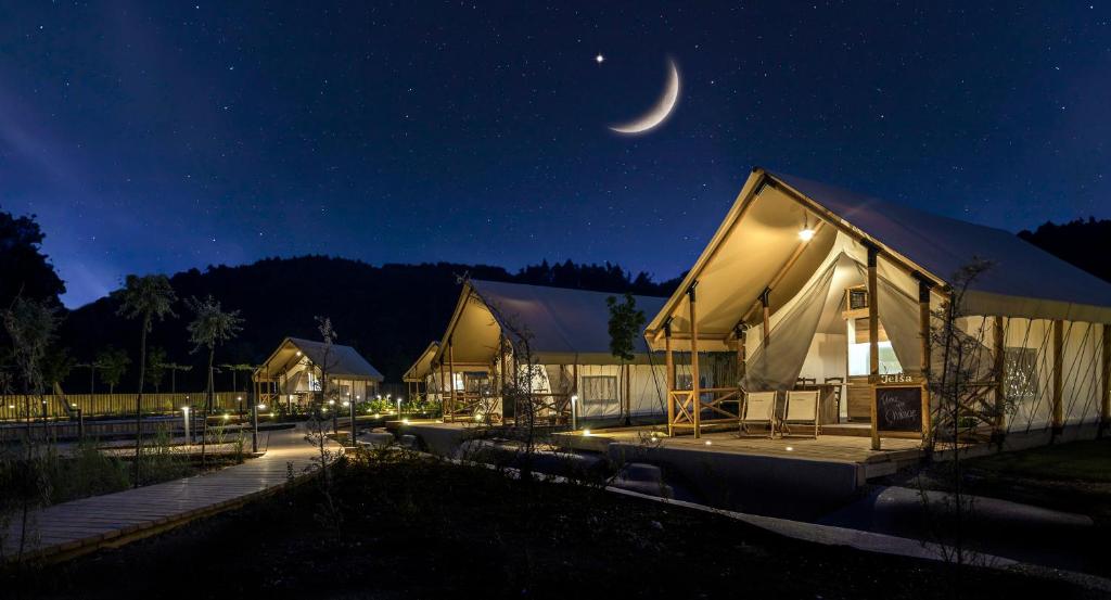 a moon over a luxury tent at night at Glamping Olimia Adria village in Podčetrtek