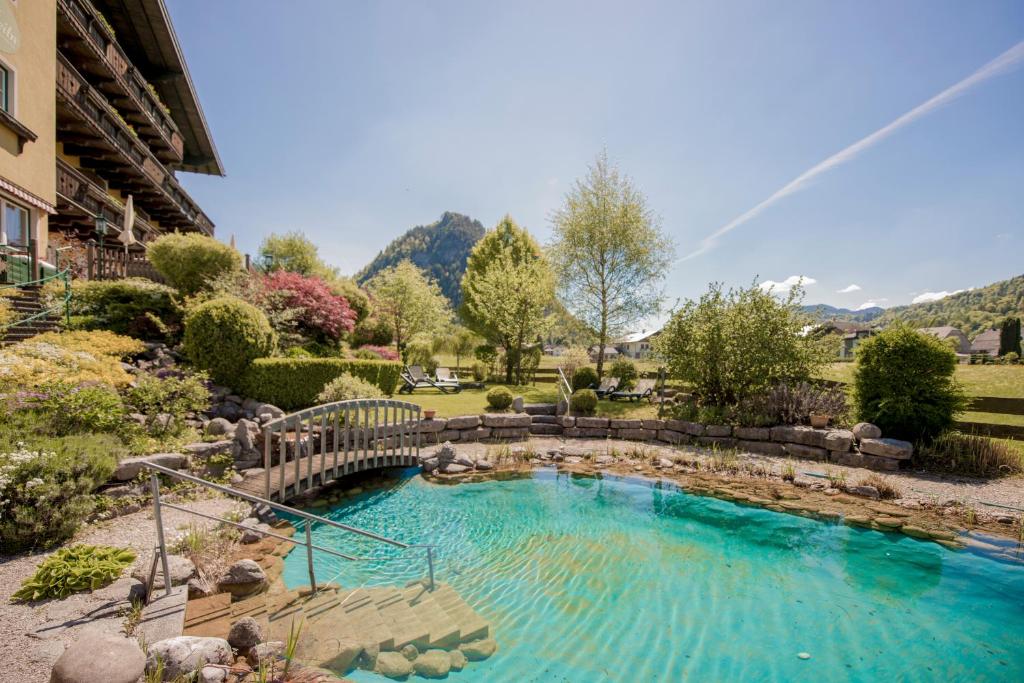 a swimming pool with a bridge in a yard at Garni Haus Sonnleitn - Adults only in Fuschl am See