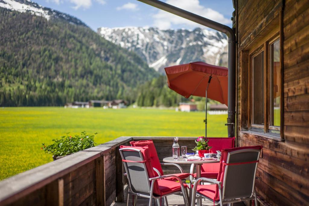 een tafel en stoelen op een veranda met uitzicht op een berg bij Haus Karoline in Achenkirch