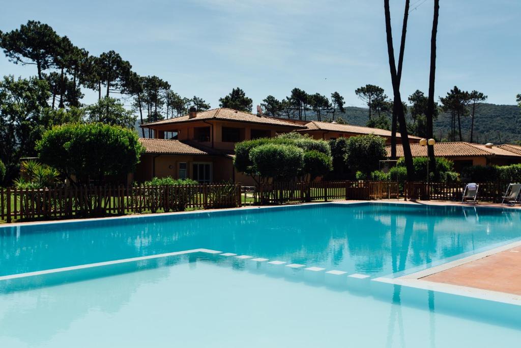 a large swimming pool in front of a house at Residence Renaione in Punta Ala