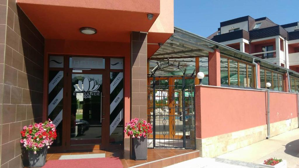 a building with two vases of flowers in front of it at Elegance Spa Hotel in Ognyanovo