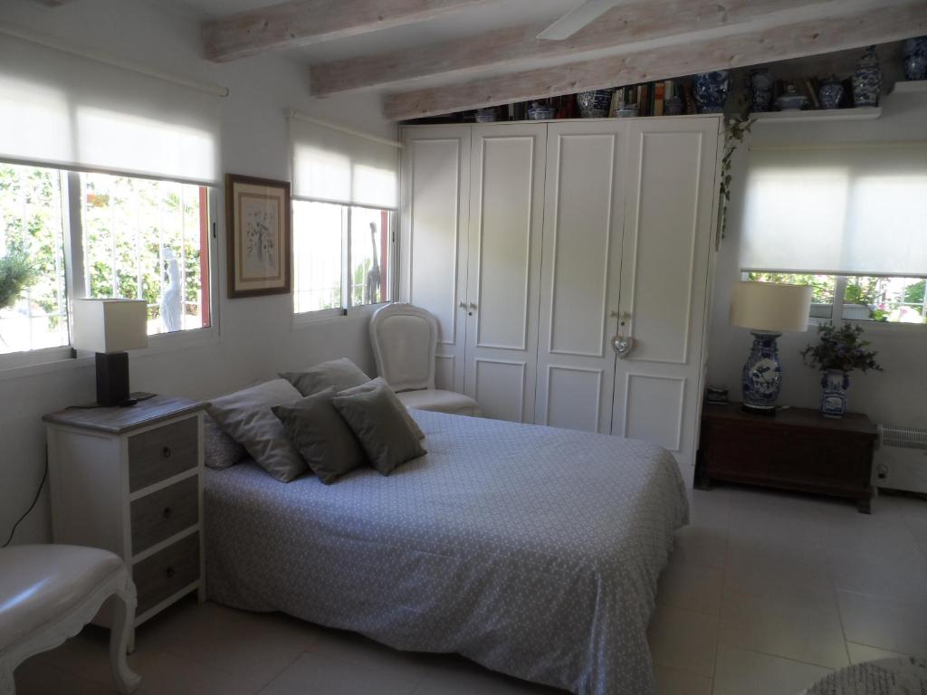 ブリアナにあるCasa con jardín frente Playa de Burrianaのベッドルーム1室(ベッド1台、椅子、窓付)