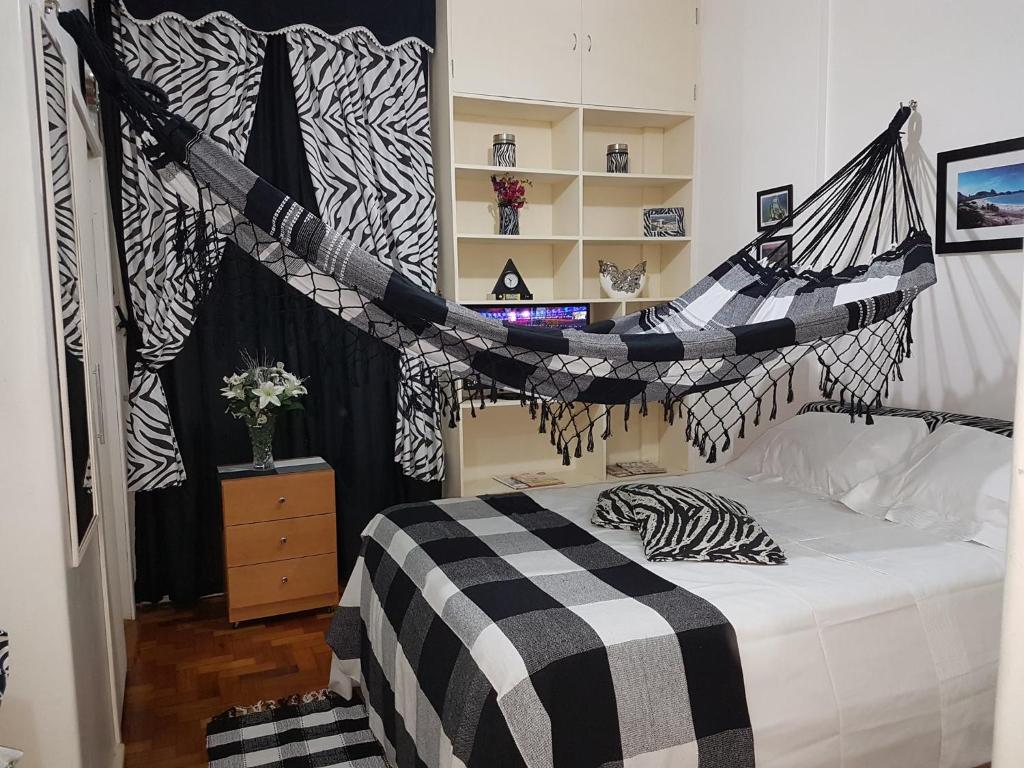 1 dormitorio con 1 cama con manta blanca y negra en COPACABANA RIO QUADRA da PRAIA, en Río de Janeiro