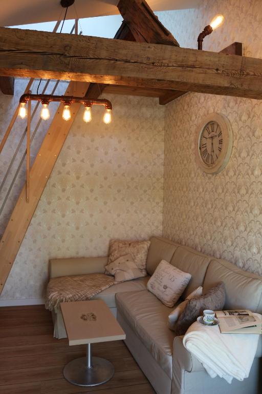 - un salon avec un canapé et un réveil sur le mur dans l'établissement Dompanorama-Kleines Ferienloft, à Havelberg
