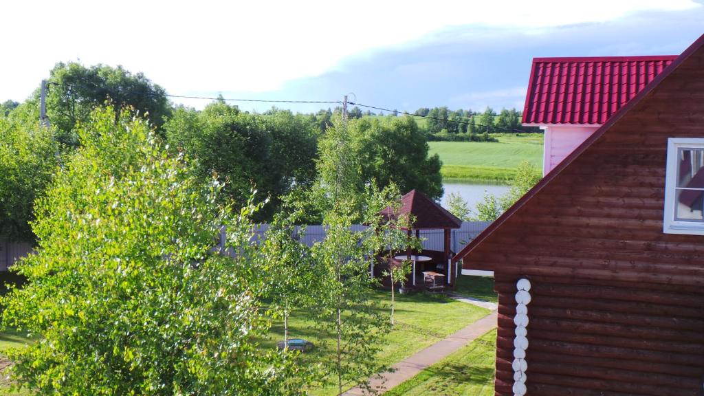 un edificio con techo rojo y una casa con árboles en Hunter Village, en Uglich