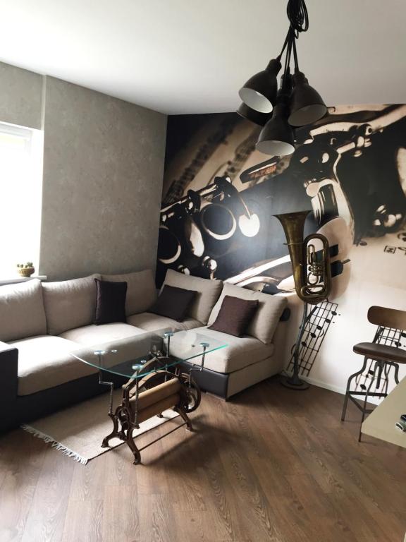 - un salon avec un canapé et un mur de guitare dans l'établissement Apartament Birutes 22, à Klaipėda