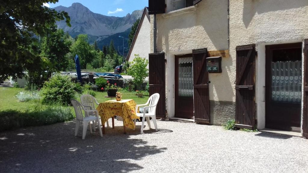 einen Tisch und Stühle außerhalb eines Gebäudes in der Unterkunft Gite Seguret in Gresse-en-Vercors