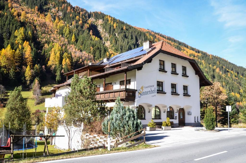 un gran edificio blanco en el lateral de una montaña en Sonnenhof - Apartments & Zimmer en Kaunertal