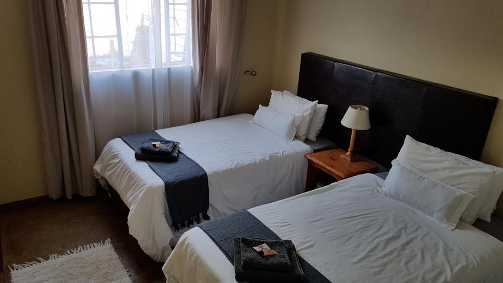 een hotelkamer met 2 bedden en een raam bij 298 on 34th in Pretoria