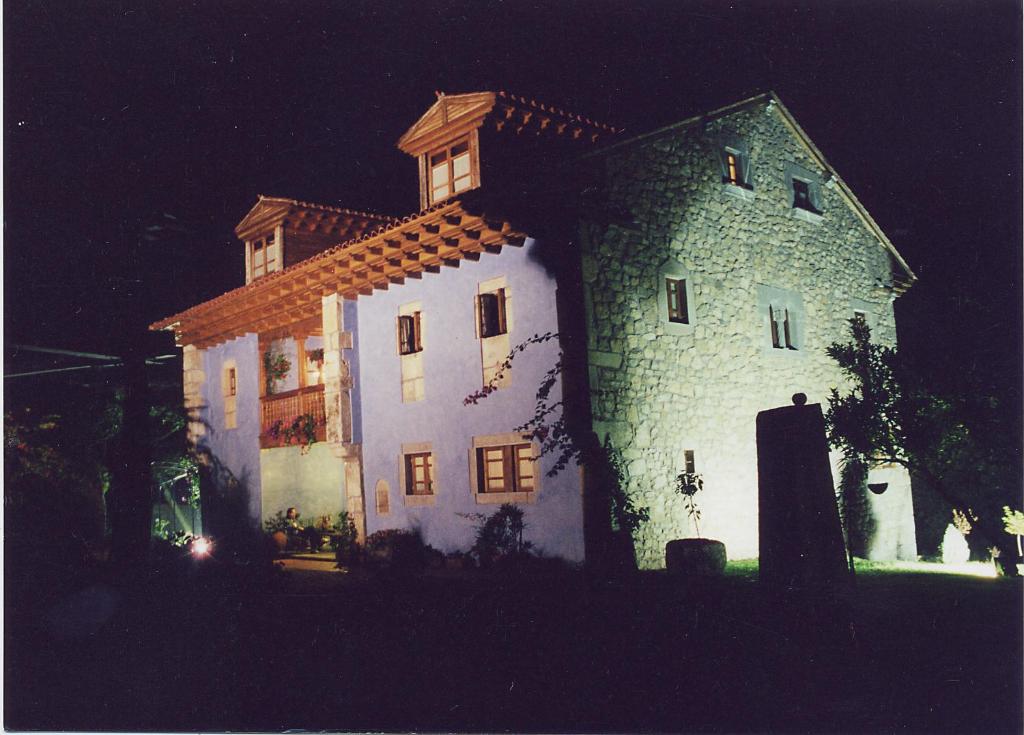a large white building with a roof at night at El Ama De Llaves in Hontoria