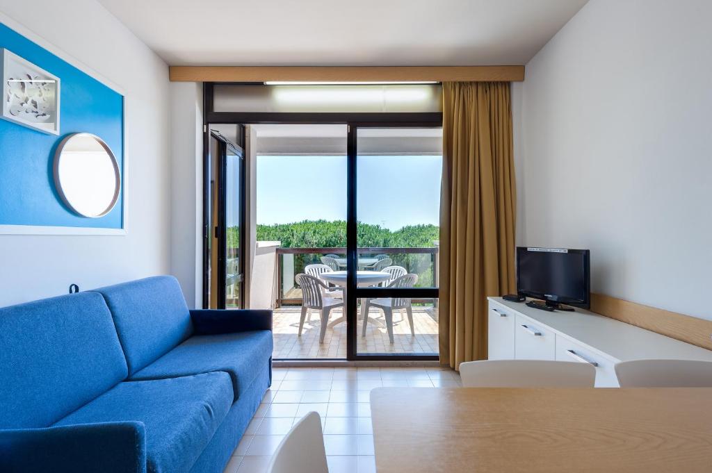 sala de estar con sofá azul y mesa en Residence Annamaria, en Bibione