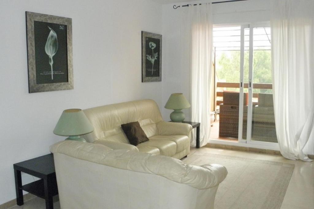 ein Wohnzimmer mit einem weißen Sofa und einem Fenster in der Unterkunft Apartament in Paraiso de la Bahia in Casares