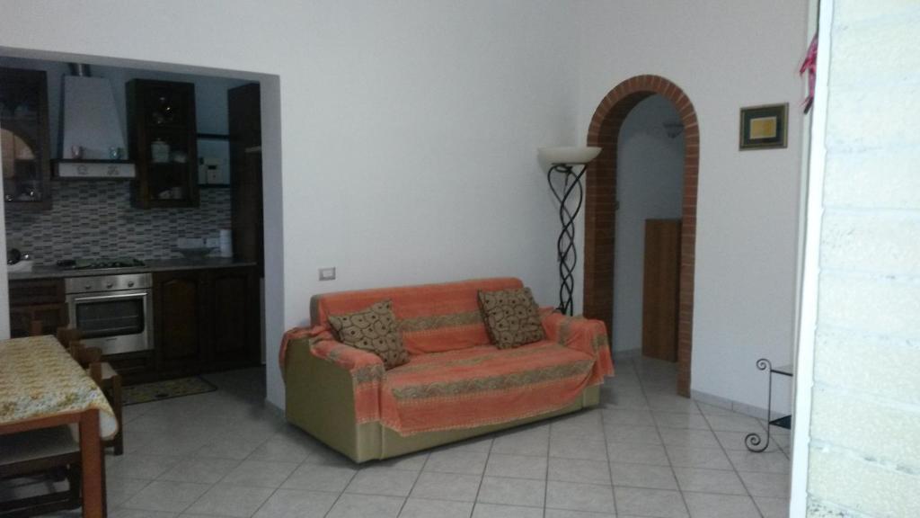 un soggiorno con sedia arancione e una cucina di Casa Gialla a Santo Stefano di Magra