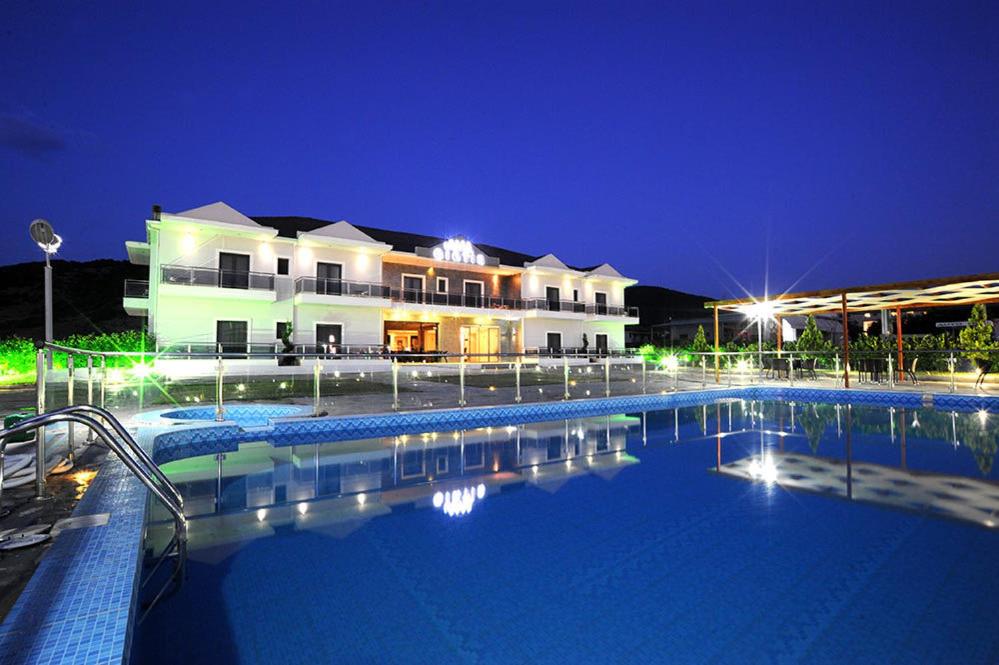 a large swimming pool in front of a building at night at Giotis Boutique Hotel in Ioannina
