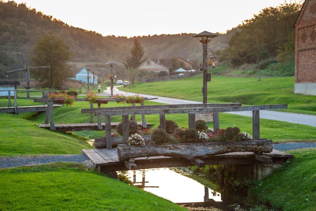 eine Holzbrücke mit Blumen auf einem Park in der Unterkunft Country House "Stričev grunt" Stara Kapela in Stara Kapela