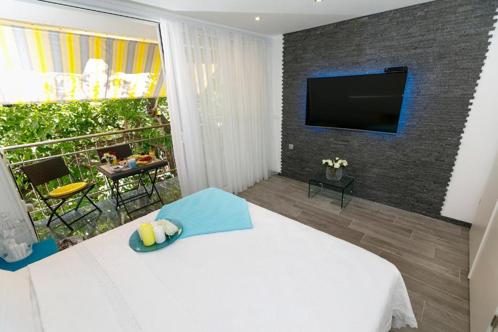 a bedroom with a bed and a balcony with a television at Rose Apartment in Split