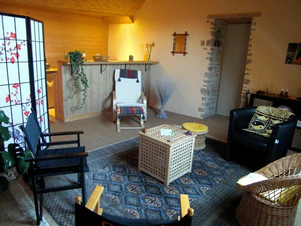 sala de estar con sillas y mesa en Les Hirondelles en Sainte-Suzanne