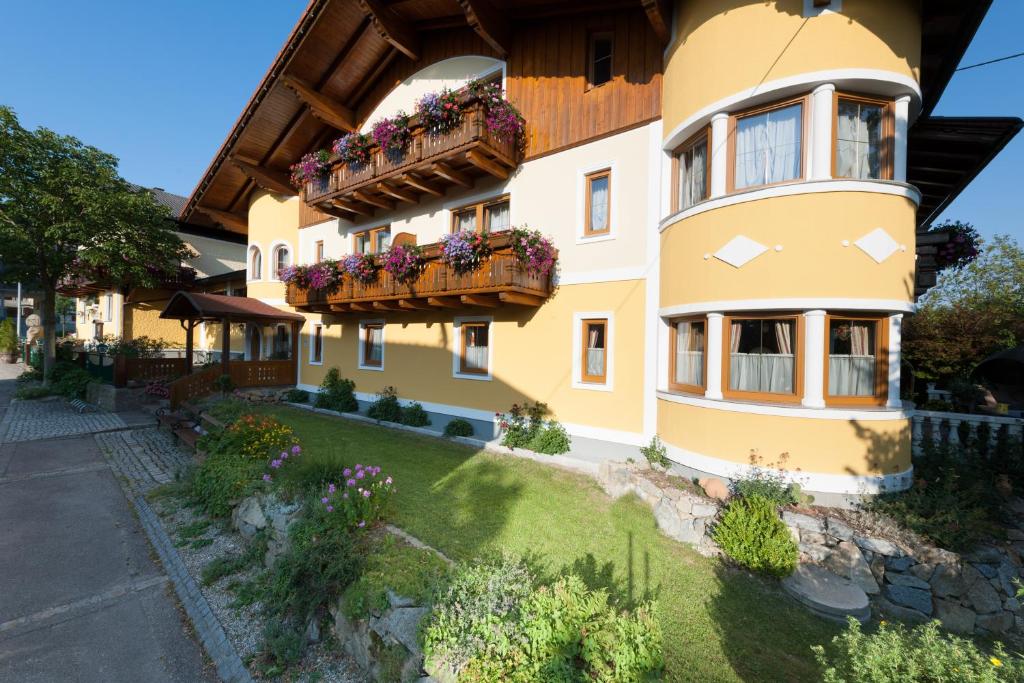 ein Haus mit zwei Balkonen und Blumen darauf in der Unterkunft Ferienhotel Innviertel in Kirchheim im Innkreis