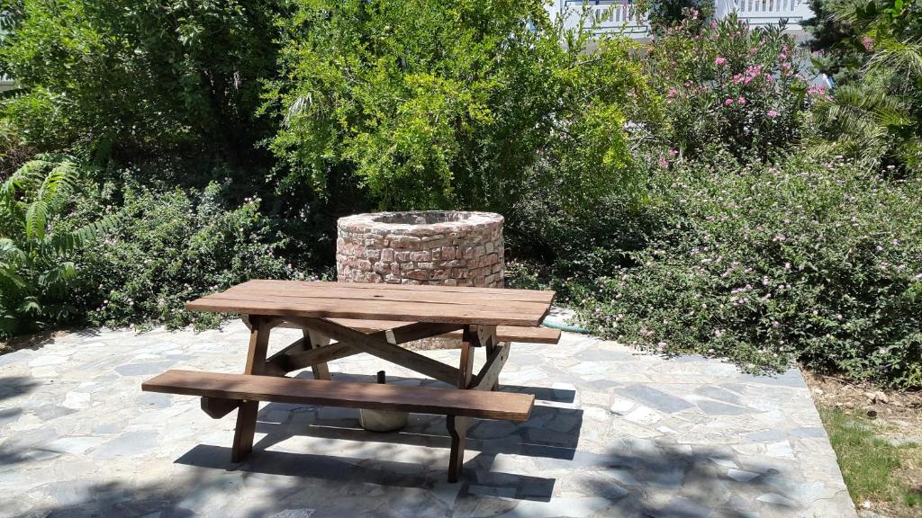 una mesa de picnic de madera y un banco en un jardín en Stelios Rooms, en Palaiochóra