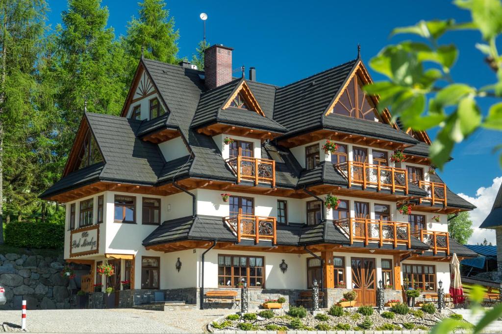 a large wooden house with a black roof at Willa Pod Miedzą 200 m do Term in Bukowina Tatrzańska