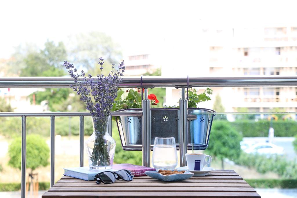 a table with a vase of flowers and glasses on a balcony at Persani Hotel-Free Parking in Sunny Beach