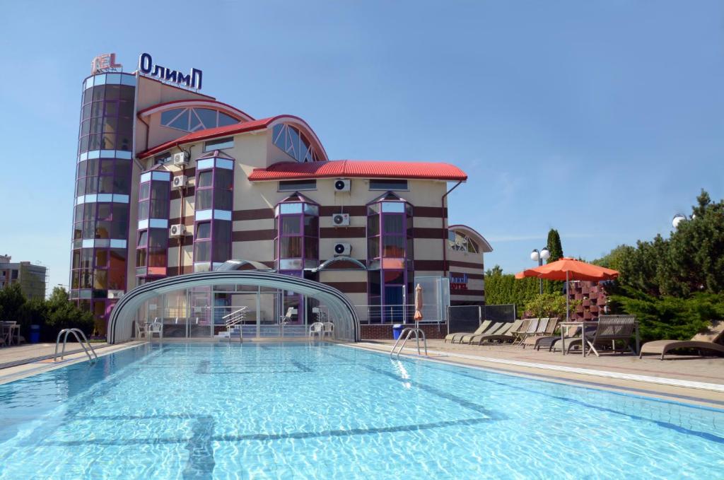 a hotel with a swimming pool in front of a building at Olimp Hotel in Svetlogorsk